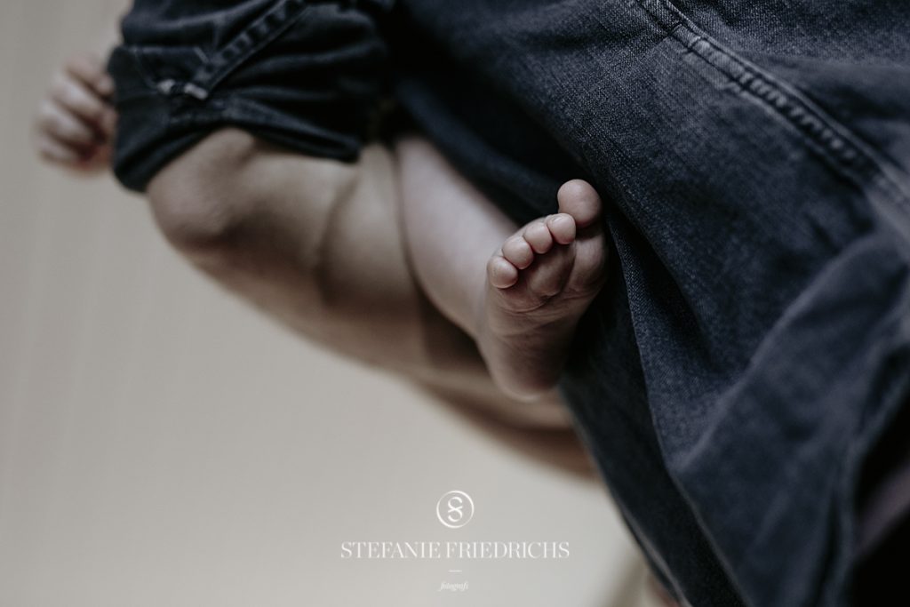 detaljebillede af babys fod og fars arm