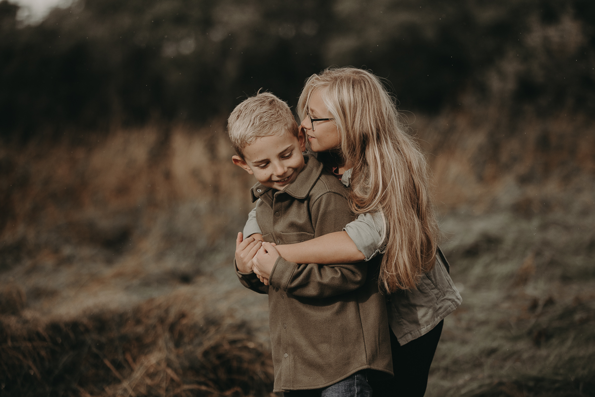 søskende krammer og leger under fotografering